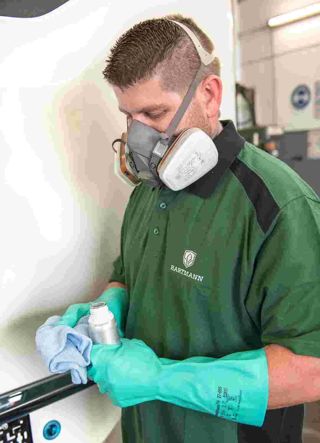 Mitarbeiter mit Atemschutzmaske trägt eine Keramikversiegelung auf ein Wohnmobil auf